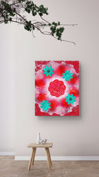 red and teal floral art print displayed on a cream coloured wall with a plant hanging above it and a small stool below with a few ceramic items 